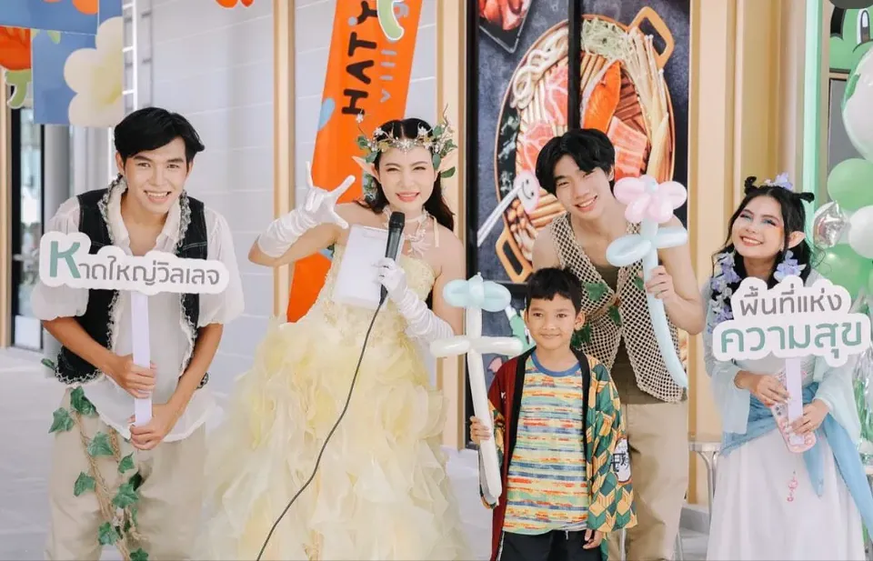 นักแสดงถือลูกโป่งดัดถ่ายภาพร่วมกับผู้ร่วมงาน
