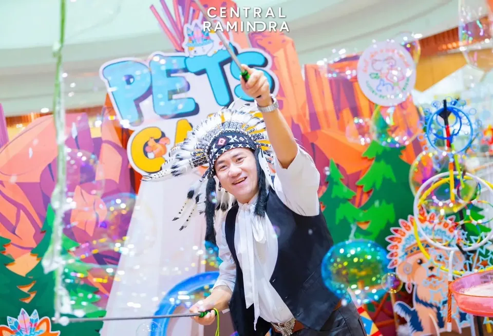 นักแสดงบับเบิ้ลโชว์ถือไม้ฟองสบู่บนเวทีตกแต่งสีสันสดใส