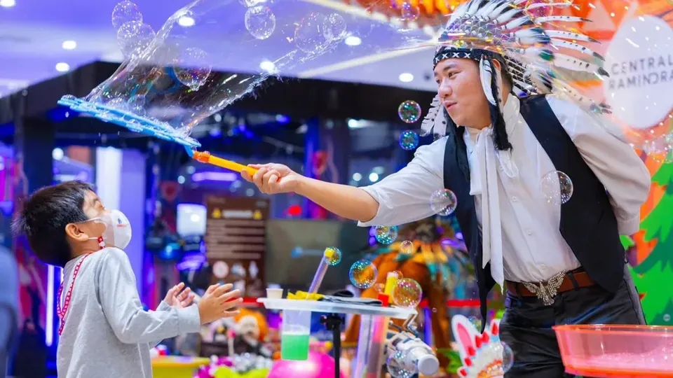 นักแสดงบับเบิ้ลโชว์สร้างฟองสบู่ให้เด็กที่ยื่นมือรับด้วยความตื่นเต้น