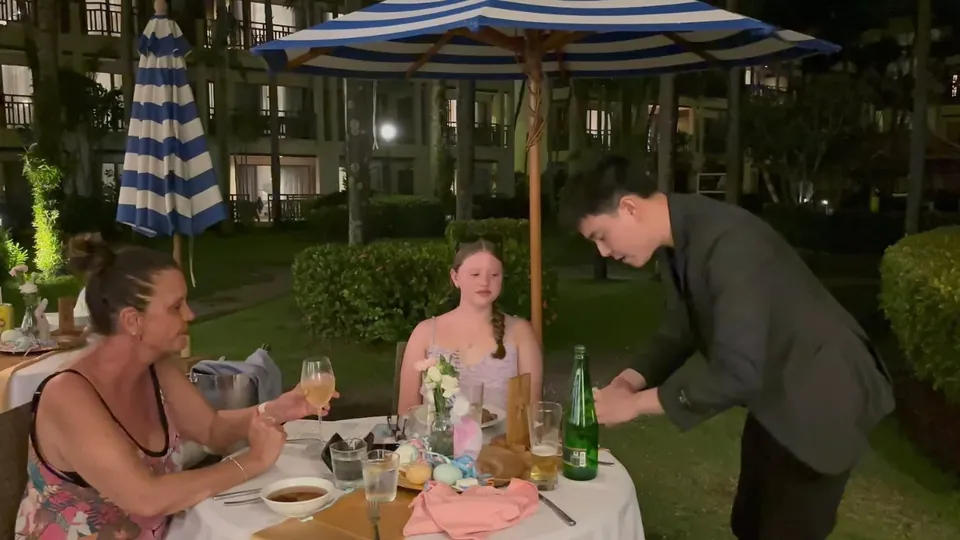 นักมายากลเดินแสดงระหว่างโต๊ะแขกในสวนของโรงแรม