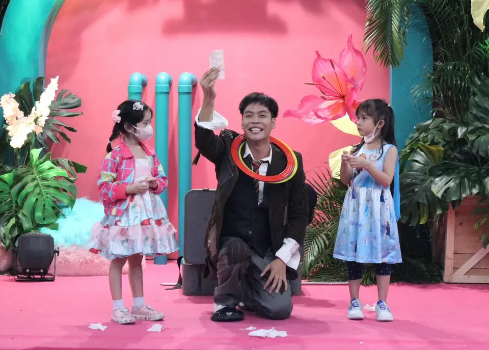 นักแสดงจั๊กกลิ้งเล่นกับเด็กสองคนบนเวทีงานอีเวนต์