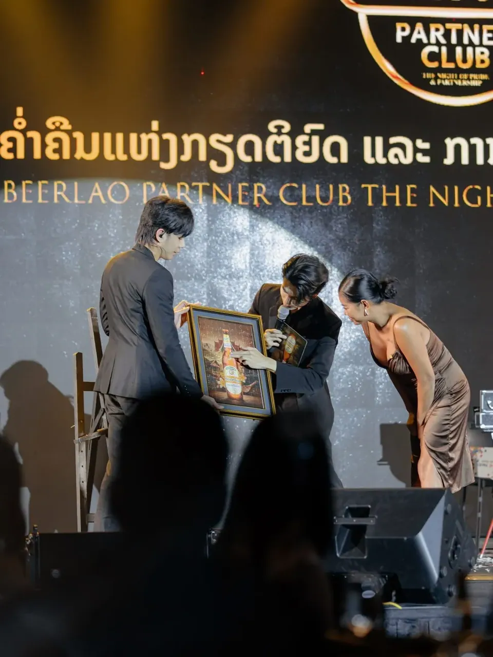 พิธีเปิดตัวบนเวทีงานกาลาดินเนอร์ ช่างภาพบันทึกภาพขณะเปิดผ้าคลุม