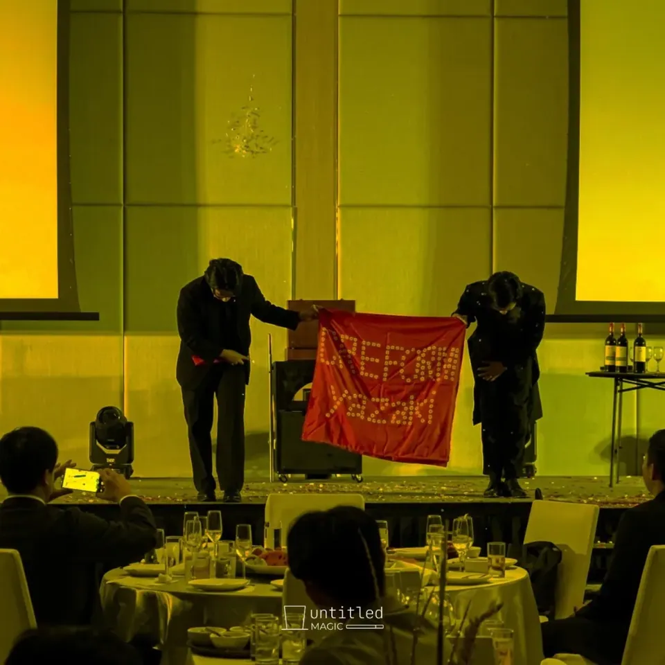 นักแสดงสองคนเปิดผ้าบนเวทีในงานเลี้ยงห้องจัดเลี้ยง