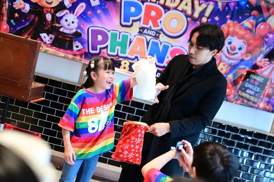 นักมายากลแสดงร่วมกับอาสาสมัครเด็กในงานวันเกิด